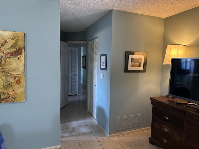 1805 Springwood Dr, Sarasota, FL 34232 - corridor featuring light tile patterned floors, a textured ceiling, and baseboards