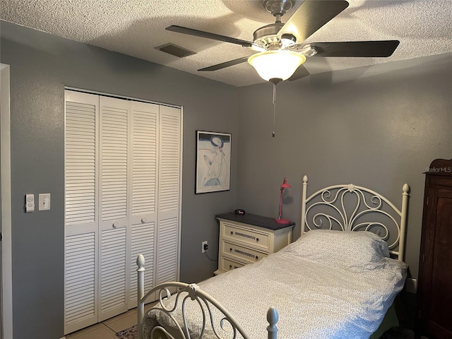 1805 Springwood Dr, Sarasota, FL 34232 - bedroom with a closet, a textured ceiling, ceiling fan, and tile patterned flooring