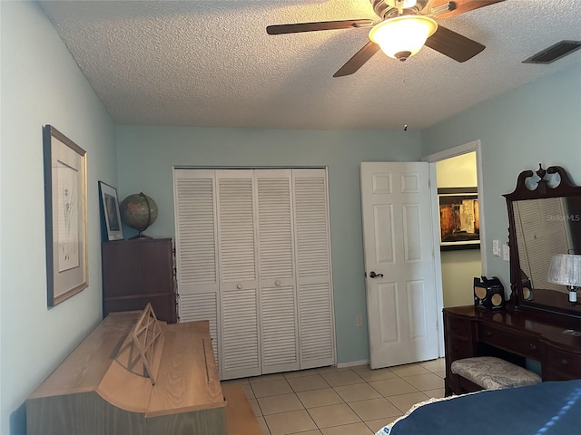1805 Springwood Dr, Sarasota, FL 34232 - bedroom with light tile patterned floors, a closet, a textured ceiling, and a ceiling fan
