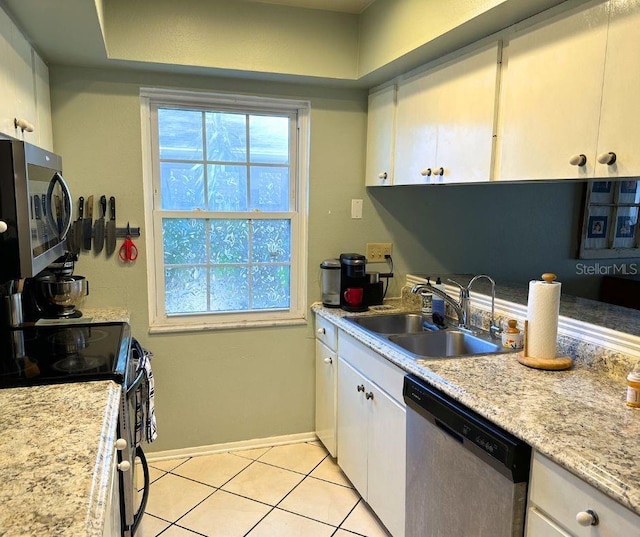 1805 Springwood Dr, Sarasota, FL 34232 - kitchen with stainless steel appliances, a sink, white cabinetry, light countertops, and light tile patterned flooring