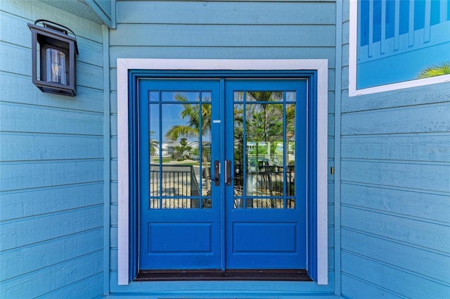 view of exterior entry featuring a garage and french doors