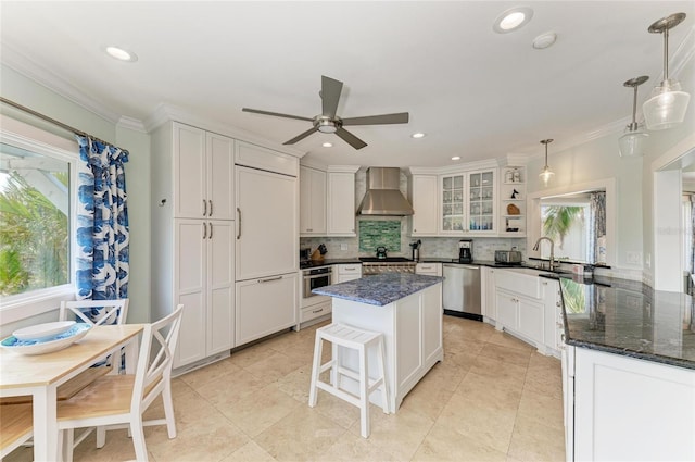 kitchen with crown molding, wall chimney exhaust hood, backsplash, and stainless steel appliances