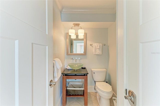 half bath featuring tile patterned flooring, crown molding, vanity, and toilet