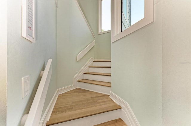 stairway with baseboards and wood finished floors