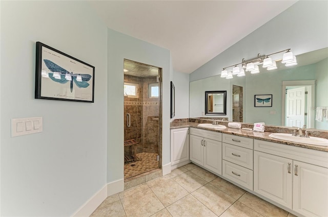 bathroom with lofted ceiling, a stall shower, a sink, and tile patterned floors