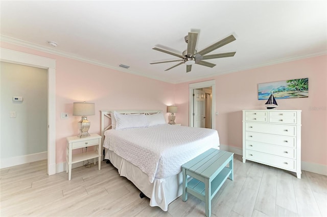 bedroom featuring light wood finished floors, baseboards, visible vents, and crown molding