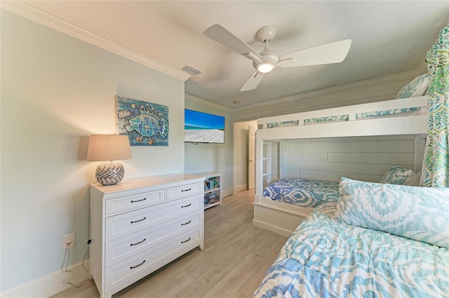 bedroom featuring light wood-style floors, visible vents, crown molding, and a ceiling fan