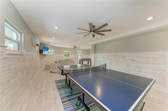 game room featuring recessed lighting, a wainscoted wall, wood finished floors, a ceiling fan, and an AC wall unit