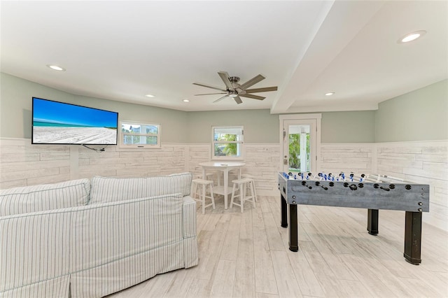 playroom with recessed lighting, a wainscoted wall, and light wood-style flooring