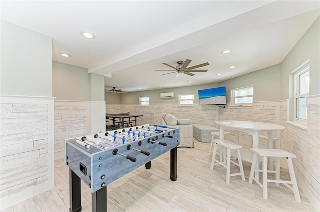 game room with a wainscoted wall, recessed lighting, a ceiling fan, wood finished floors, and a wall mounted air conditioner