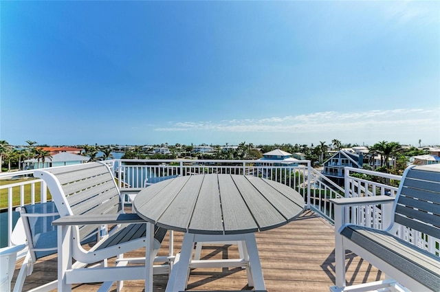 wooden deck with outdoor dining space and a water view