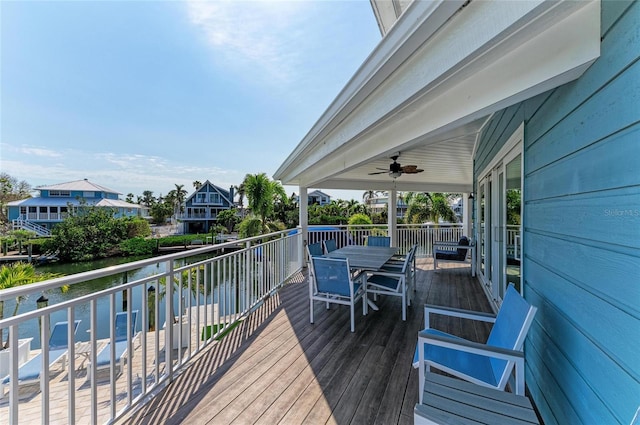 deck featuring a water view, ceiling fan, and outdoor dining space