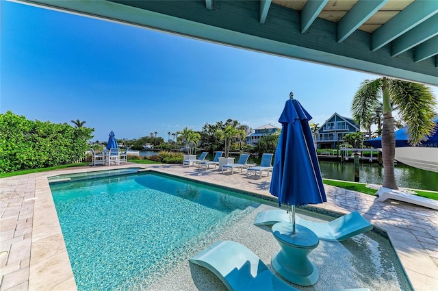 outdoor pool featuring a water view and a patio area