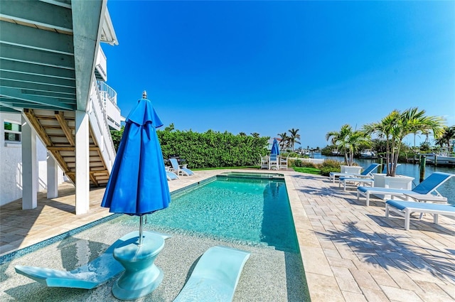 view of swimming pool featuring a fenced in pool, a patio area, and stairway