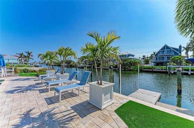 exterior space with a water view, fence, and a dock