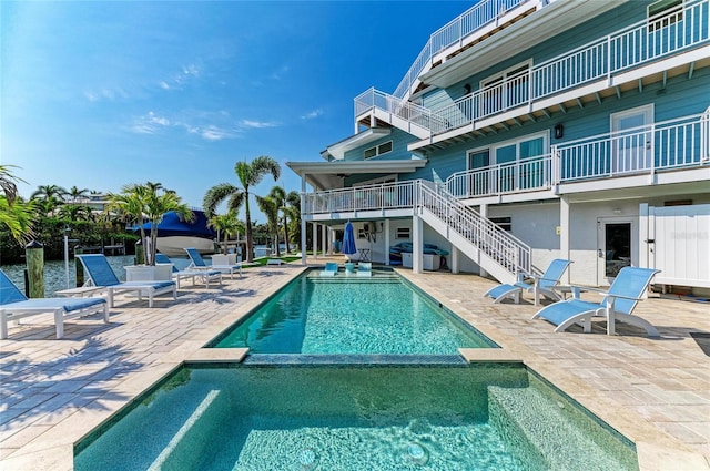 view of swimming pool with a pool with connected hot tub, stairs, area for grilling, and a patio