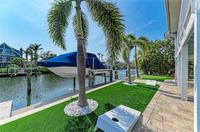 view of yard with a water view, a boat dock, and boat lift