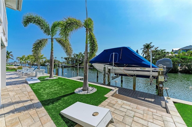 view of dock featuring a lawn, a water view, and boat lift