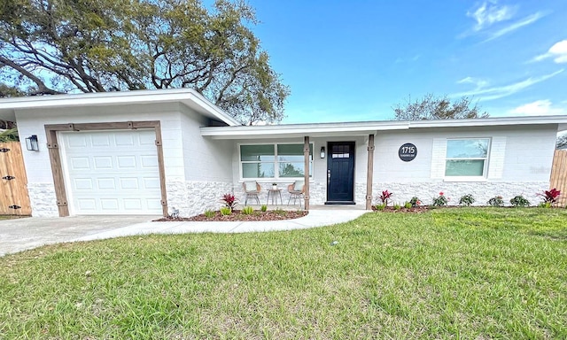 ranch-style home with concrete driveway, stone siding, an attached garage, a porch, and a front yard