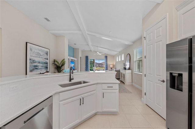 kitchen with vaulted ceiling with beams, light tile patterned floors, a sink, open floor plan, and appliances with stainless steel finishes