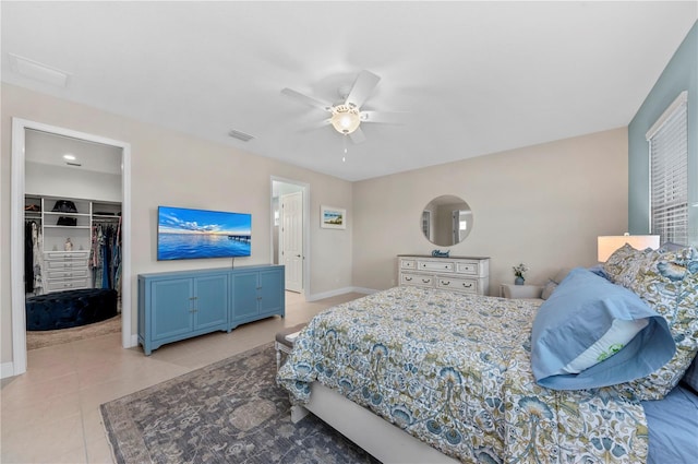 tiled bedroom with visible vents, baseboards, a ceiling fan, a spacious closet, and a closet