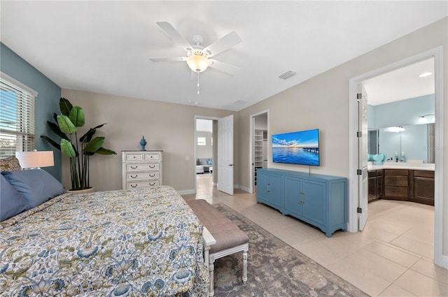 bedroom with light tile patterned floors, baseboards, visible vents, a ceiling fan, and ensuite bath