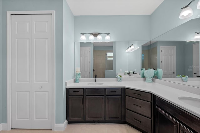 bathroom with a closet, a sink, and double vanity