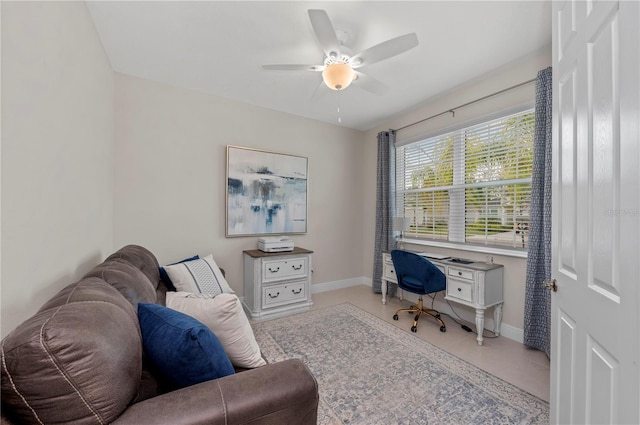 tiled office space with ceiling fan and baseboards