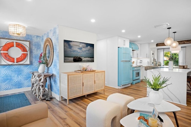 living room with visible vents, wallpapered walls, baseboards, recessed lighting, and light wood-style flooring