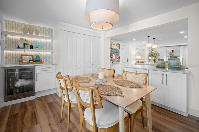 dining area featuring wine cooler, recessed lighting, wood finished floors, and a dry bar