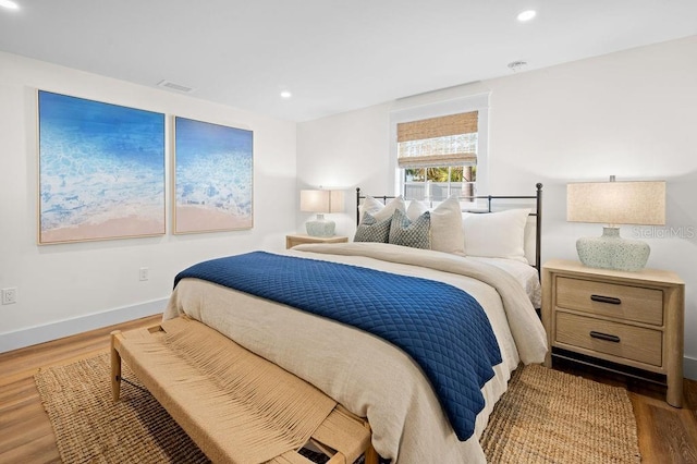 bedroom with recessed lighting, baseboards, and wood finished floors