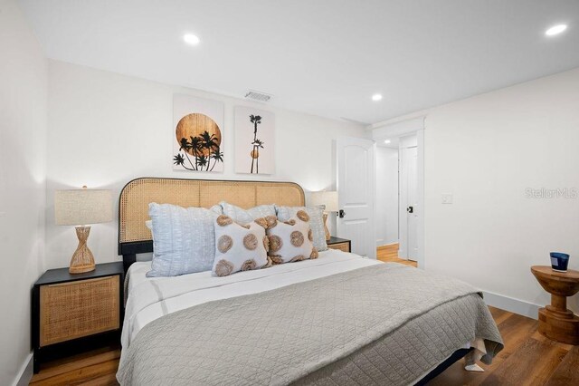 bedroom featuring recessed lighting, wood finished floors, visible vents, and baseboards