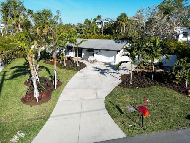 view of front of property featuring a garage, concrete driveway, and a front yard