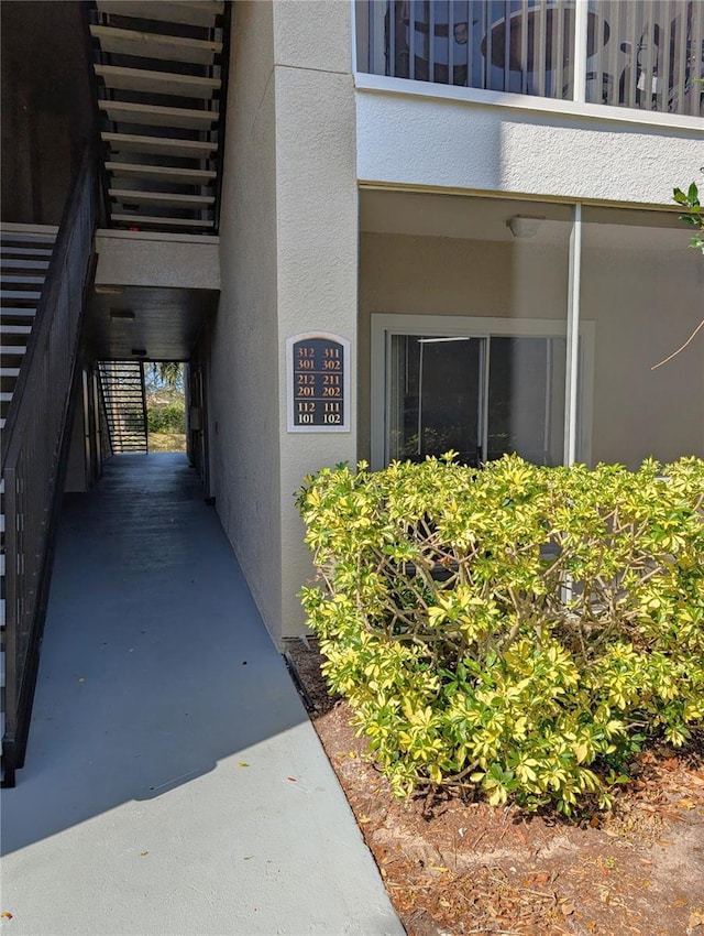 entrance to property featuring a balcony and stucco siding