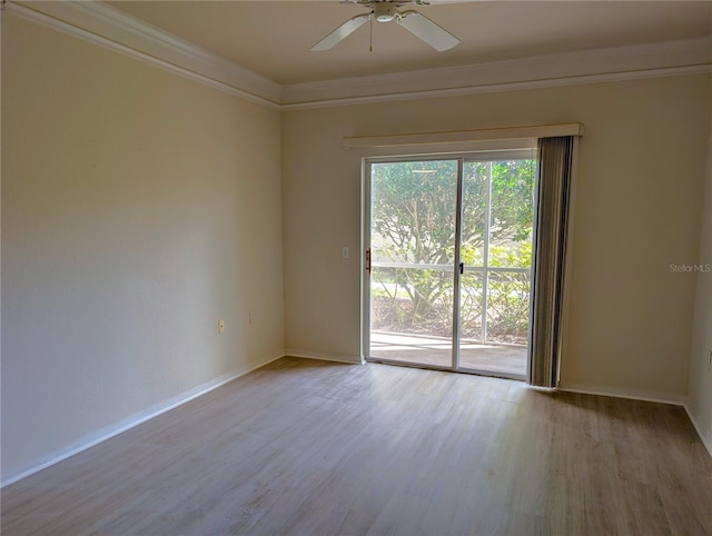 empty room featuring baseboards, wood finished floors, a ceiling fan, and crown molding