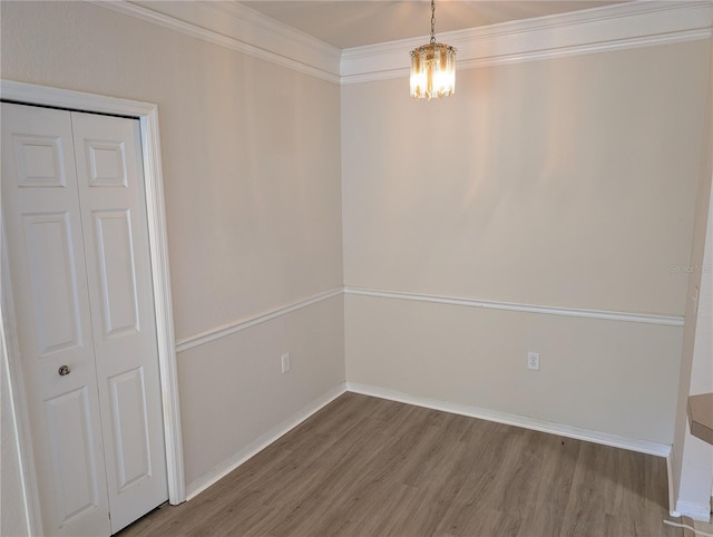 interior space featuring an inviting chandelier, baseboards, ornamental molding, and wood finished floors