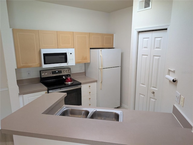 kitchen featuring white appliances, backsplash, light brown cabinets, and visible vents