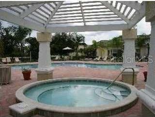 community pool with a community hot tub and a gazebo