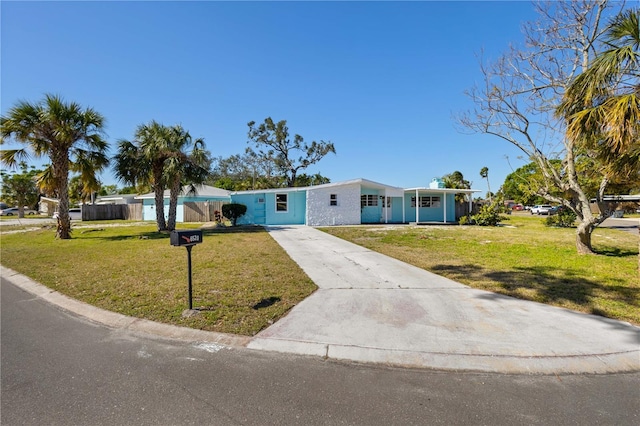 view of front facade with concrete driveway and a front yard