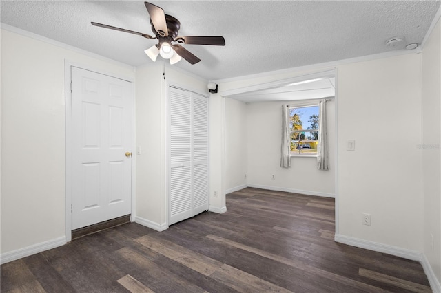 unfurnished bedroom with a textured ceiling, baseboards, and wood finished floors