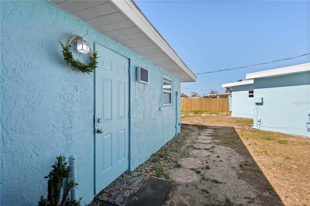 view of home's exterior with fence and stucco siding