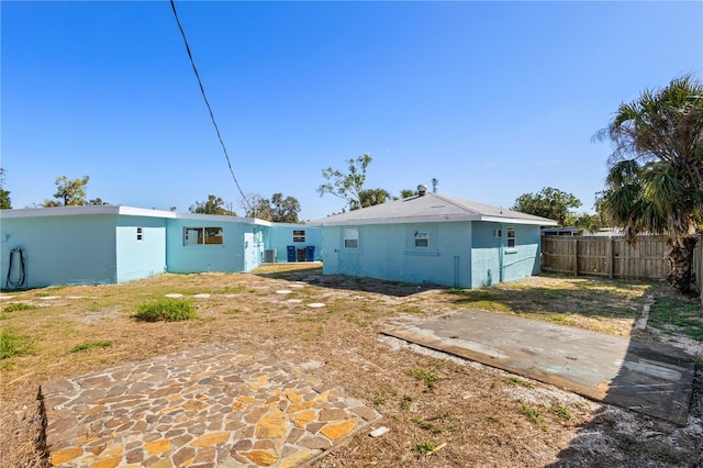 back of house featuring fence and stucco siding