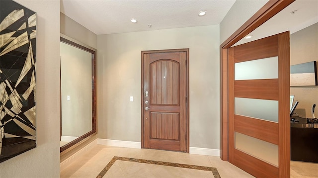 foyer entrance featuring recessed lighting, baseboards, and a textured ceiling