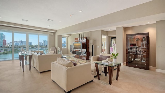 living room with light tile patterned floors, visible vents, recessed lighting, and baseboards