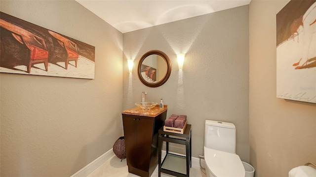 half bath with vanity, toilet, and baseboards