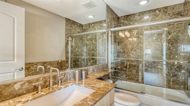 full bathroom with visible vents, toilet, decorative backsplash, enclosed tub / shower combo, and vanity