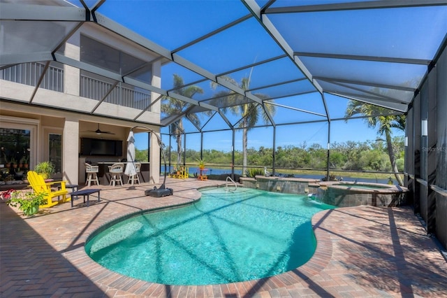 view of pool with a ceiling fan, glass enclosure, a pool with connected hot tub, and a patio area