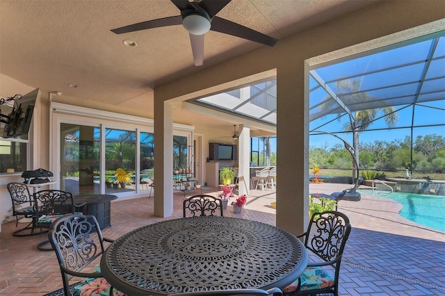 view of patio with an outdoor pool, outdoor dining space, a lanai, and ceiling fan