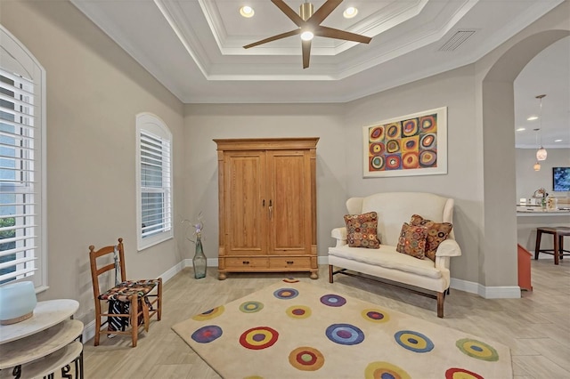 sitting room featuring baseboards, visible vents, arched walkways, ceiling fan, and crown molding