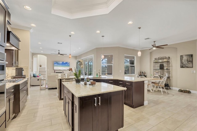 kitchen featuring ornamental molding, backsplash, dark brown cabinets, and a center island